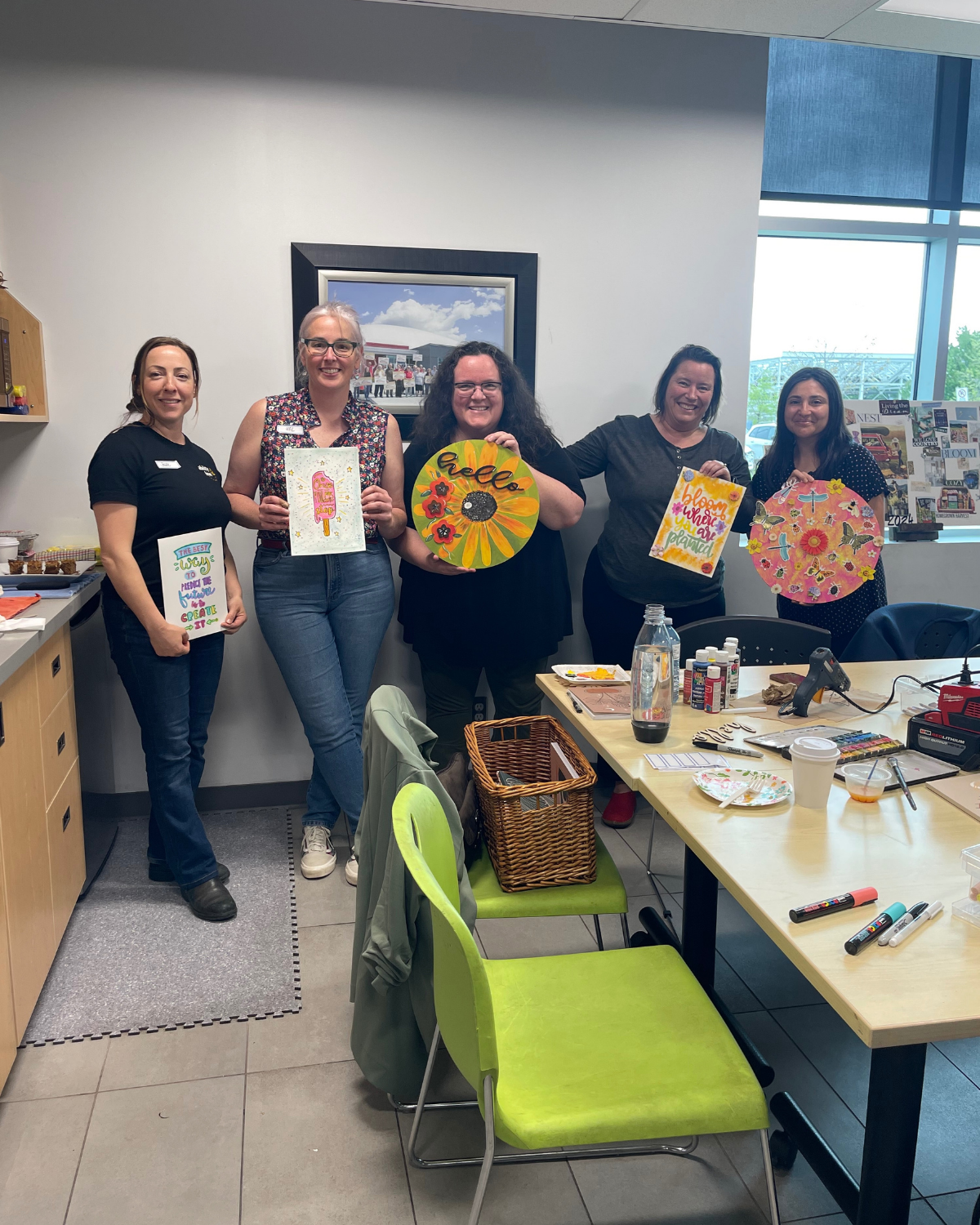 Group of women in a room holding colorful art pieces, with a table and chairs in the foreground. Heart & Art Budget | 2025, Nonprofit Financials, Transparency, GoūtArt Altruism