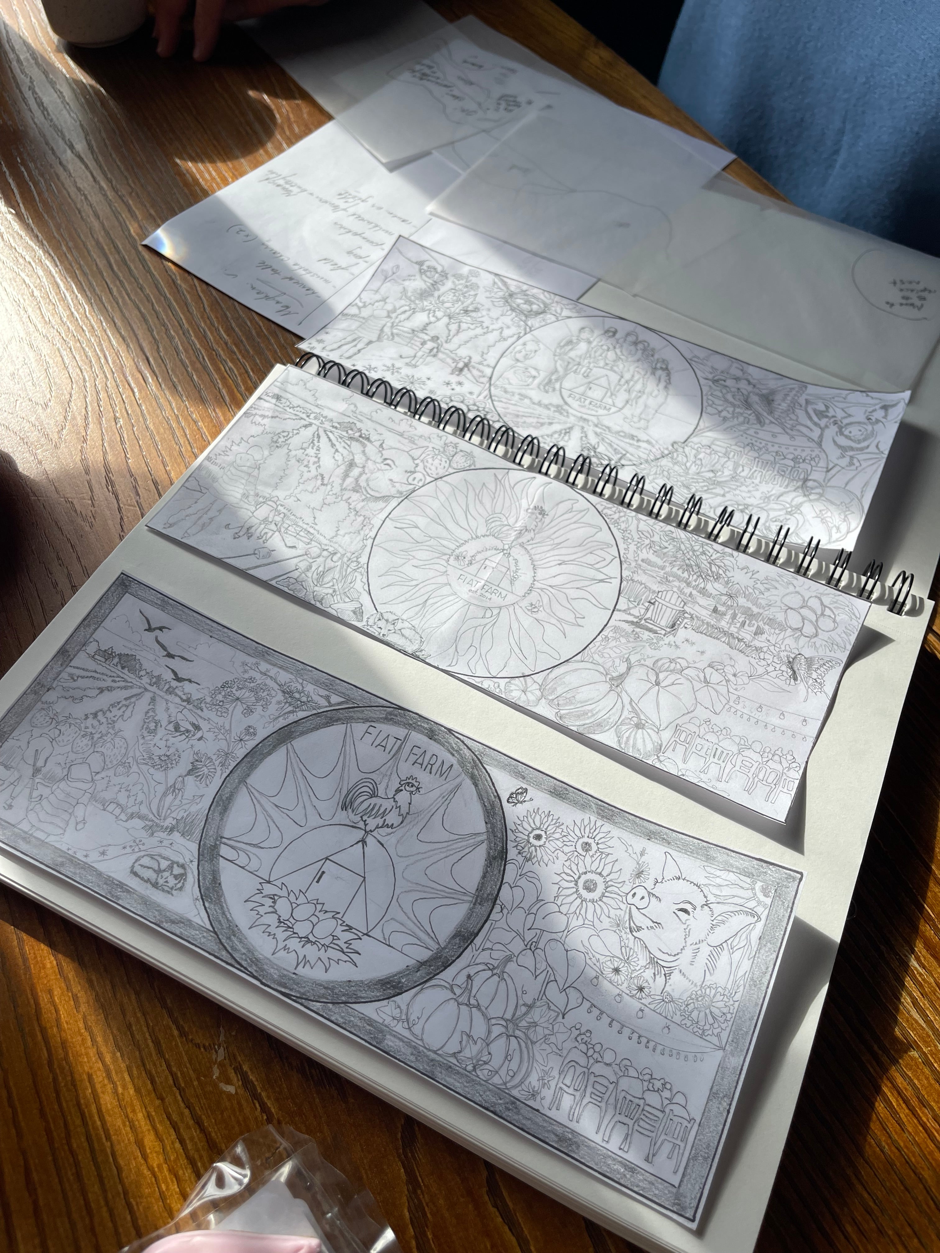 Open notebook with black and white a community mural designs on a wooden surface