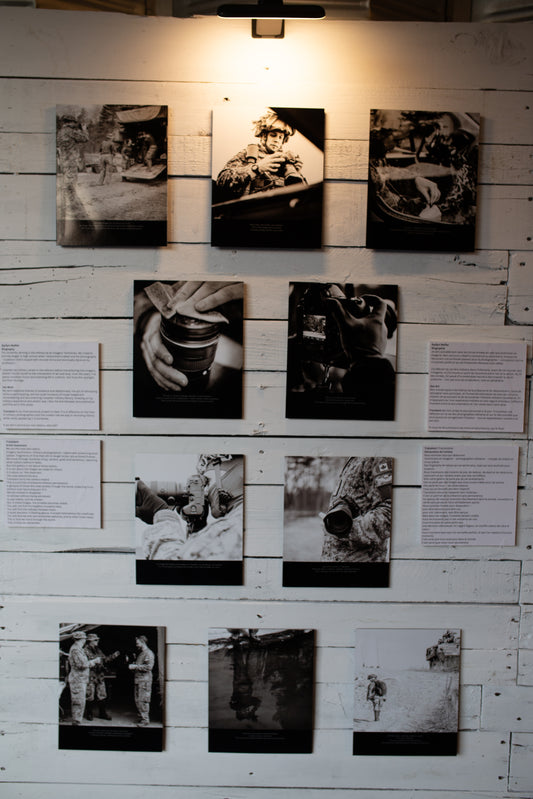 Black and white photographs displayed on a wooden wall with text panels.